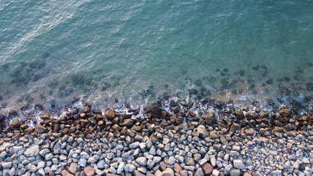 Top view of sea stones along the shore or granite pebbles. Background of wet stone by the seaの写真素材