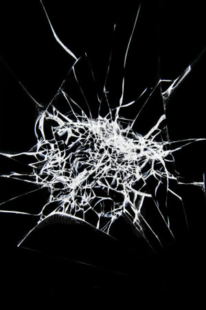 cracked and chipped broken glass on black background. Abstract collage with cracked window texture.
