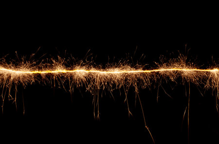 A line of sparks on a black background. Bengal light moving in the dark