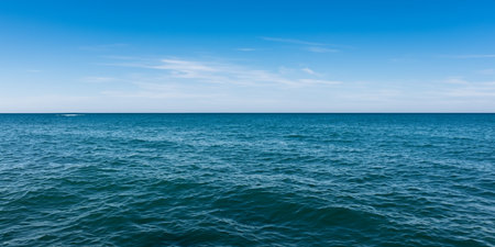 The dark blue sea and blue cloudless sky merge together on the horizon into a beautiful seascapeの素材