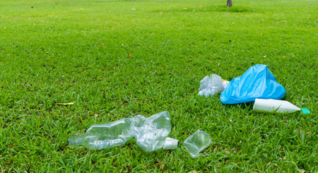 Plastic garbage left in the park on a green lawn. The concept of environmental pollutionの素材