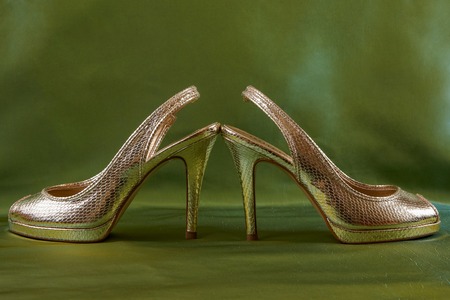 Golden elegance shoes  on green silk backgroundの写真素材