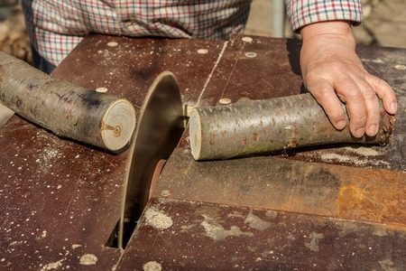 Carpenter working on woodworking machines circular saw cuts woodの写真素材