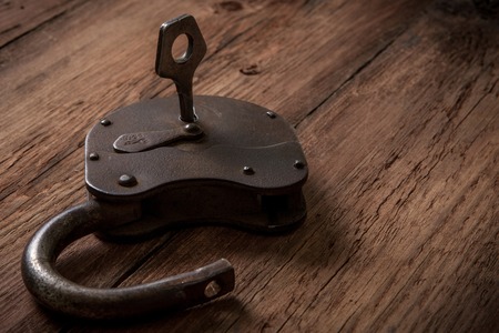 Key and rusty lock on vintage wooden backgroundの写真素材