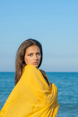 Young attractive sad girl near sea on a summer dayの写真素材
