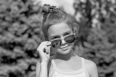 Portrait cute 8 years old girl with sunglasses. Outdoors.の写真素材