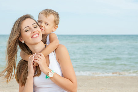 Happy family. Young happy beautiful  mother and her son having fun on the beach. Positive human emotions, feelings, emotions.の写真素材