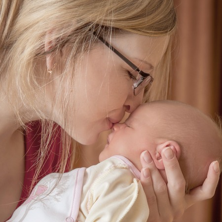 Mother and her Newborn Baby. Happy Mother and Baby kissing.  soft image of Beautiful Family. Maternity concept. Parenthood. Motherhood.の写真素材