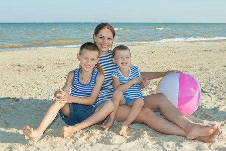 Happy family. Young happy beautiful  mother and her two sons having fun on the beach. Positive human emotions, feelings, emotions.の写真素材