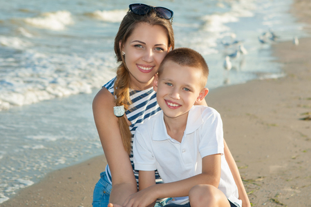 Happy family. Young happy beautiful  mother and her son having fun on the beach. Positive human emotions, feelings.の写真素材