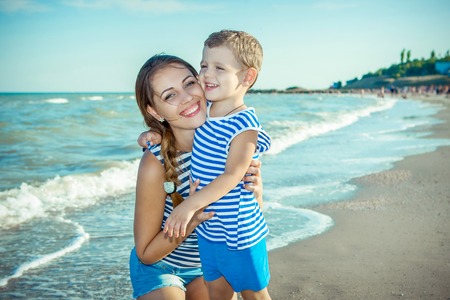 Happy family. Young happy beautiful  mother and her son having fun on the beach. Positive human emotions, feelings.の写真素材