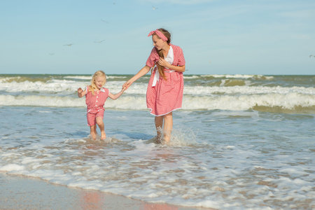 Happy family. Young beautiful  mother and her daughter  having fun on the beach. Positive human emotions, feelings.の写真素材