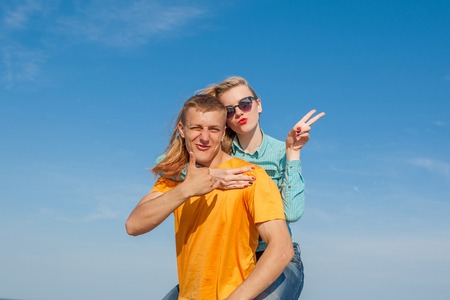 Happy young joyful guy and girl having fun on the beach, laughing together. During summer holidays vacation on sea. Beautiful energetic couple friends adolescents.の写真素材