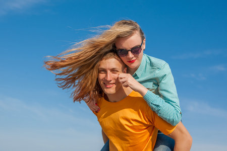 Happy young joyful guy and girl having fun on the beach, laughing together. During summer holidays vacation on sea. Beautiful energetic couple friends adolescents.の写真素材