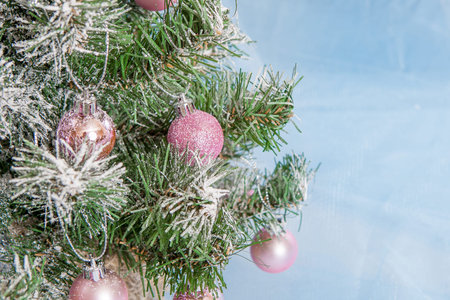 Christmas Holiday Background, Hanging pink baubles on Christmas tree, New Year backdrop, Decoration. Abstract blue Blurred Bokeh. Christmas Tree decorated.の写真素材
