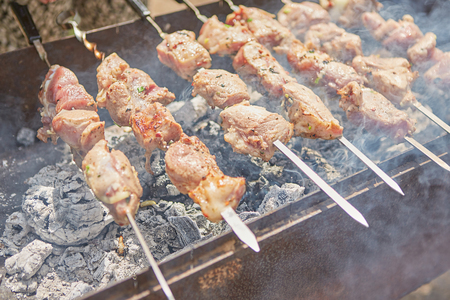 Barbecue Party With Delicious Grilled Meat On Grill. Pork or lamb meat pieces being fried on a charcoal grillの写真素材