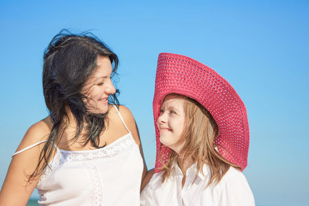 Happy family. Loving mother with seventeen-year-old daughter with Down syndrome on the beach With...