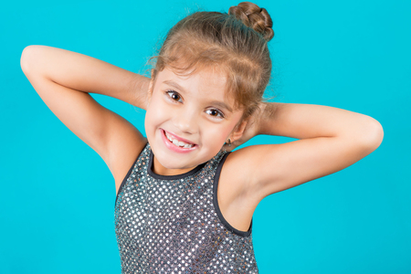 Beautiful little happy girl on blue background. Happy, cheerful, beautiful smile.の写真素材