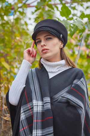 Beautiful gentle woman in the autumn park enjoys good weather and silence