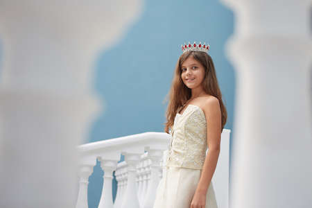 Happy little Girl in a beautiful dress, with a crown on his head .の写真素材