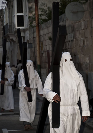 Men in hooded masks carrying a cross during Good Friday procession April 10, 2009