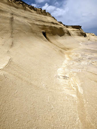 Beautiful and unique eroded sandstone cliff faces at Qbajjar in Gozoの写真素材