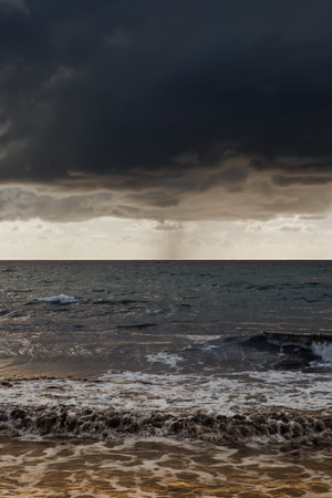 Dark grey clouds over a crisp bright horizon at Ghajn Tuffieha Bay in Maltaの写真素材