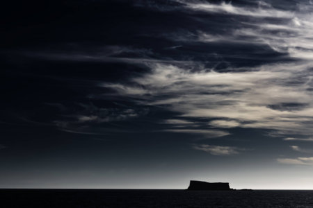 High altitude clouds over a clear sky above a silhouette of Filfla の写真素材