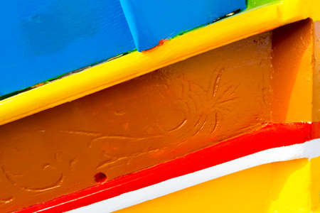 Abstract close up view of the vibrant colours and design usually used on the traditional Maltese fishing boat, the "Dghajsa" or "Luzzu".の写真素材