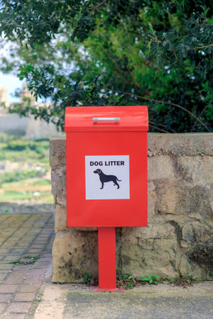 A red dog litter bin