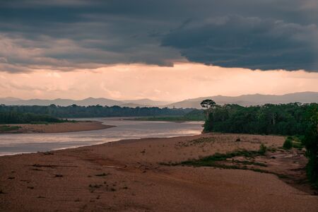 Riverbank with a dramatic sky in the rainforestの写真素材