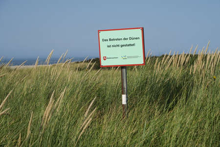 Langeoog, Lower Saxony / Germany - 09 14 2020: The sign tells: Entering the dunes is not permitted. It is German for: No admittance to the dunes.のeditorial素材