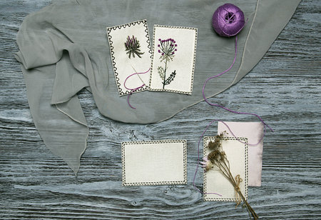 Embroidered flowers on white canvas. Rustic background