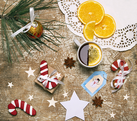 New year holiday composition of tea with lemon, napkin, stars, candy canes and anisetree seedsの写真素材