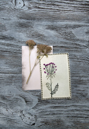 Embroidered flowers on white canvas. Rustic background