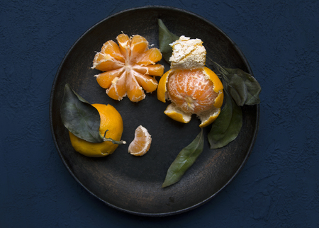 Tangerines on black plate. Dark and rustic backgroundの写真素材
