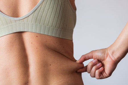 girl touches the side, folds of fat, the problem of obesityの写真素材