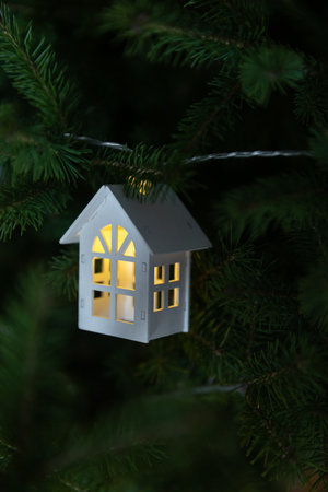 New Years house garland on the background of a green Christmas tree, housewarming concept and comfort in your home for a holidayの写真素材