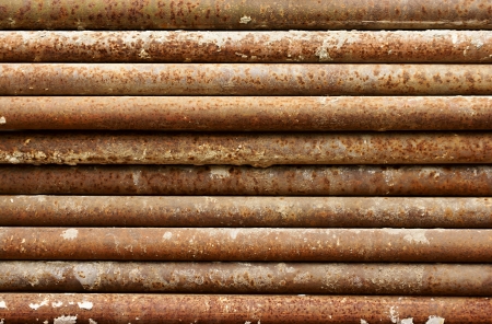 Old, rusty, dirty pipes are piled horizontallyの写真素材