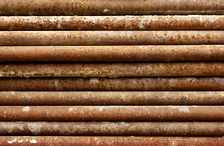 Old, rusty, dirty pipes are piled horizontallyの写真素材