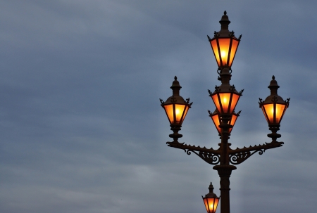 Ancient lamps on a column shine the night skyの写真素材