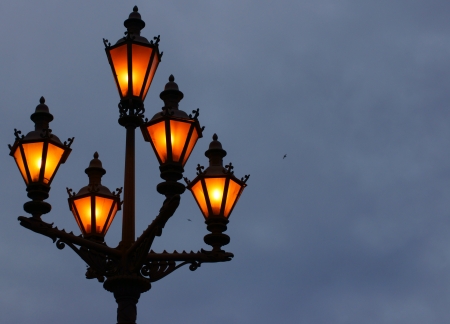 Ancient lamps on a column shine the night skyの写真素材