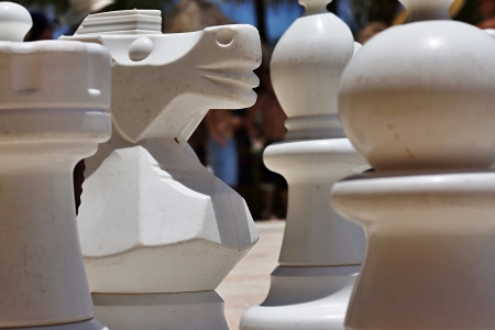 Big white figures for game in chess on a beach during restの写真素材
