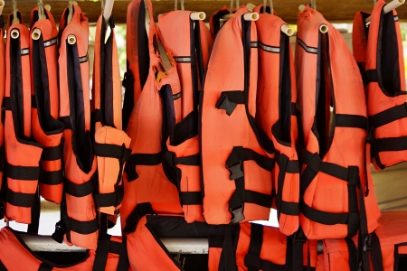 Red vests of safety for sea sports weigh in a rowの写真素材