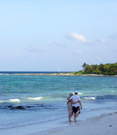 The man and the woman embraced each other and walk barefoot on the seashoreの写真素材