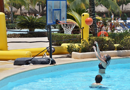 Children play basketball on water in the pool and the girl throws a ball into a basketのeditorial素材