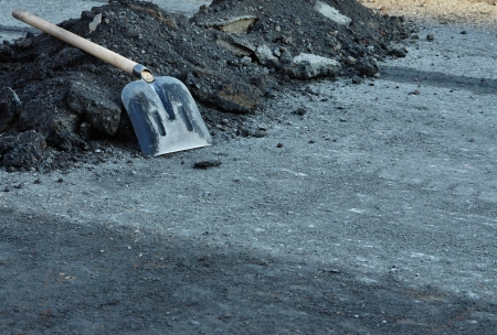 Shovel for construction works on a heap of old asphaltの写真素材