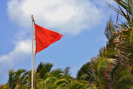 The red flag develops a wind against the blue skyの写真素材