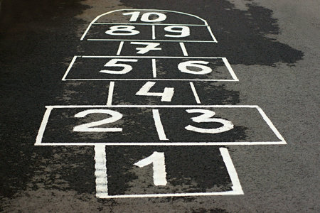 The game hopscotch for children in yard on asphalt