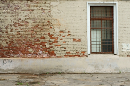 Window with a lattice on a brick wall of the old buildingの写真素材